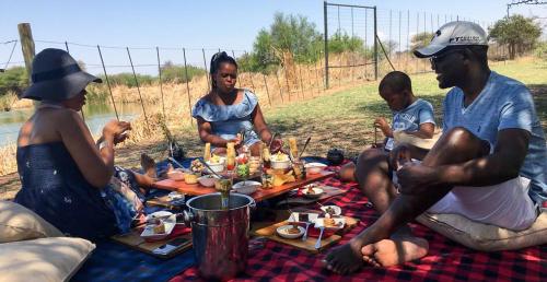 a group of people sitting around a picnic table at Ditholo Game Lodge Bela Bela in Bela-Bela