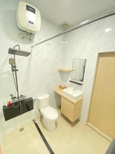 a bathroom with a toilet and a sink and a tv at Awandari Resort & Convention in Kangkakawal