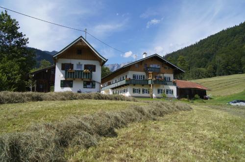 ein Haus auf einem Hügel auf einem Feld in der Unterkunft Landhaus Perllehen in Berchtesgaden