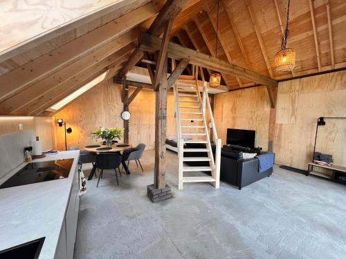 a room with a staircase and a table in a barn at Wonen in een boerenschuur uit 1899 in Zwolle