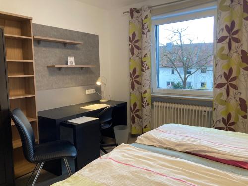 um quarto com uma secretária, uma cama e uma janela em UNIaparts em Regensburg