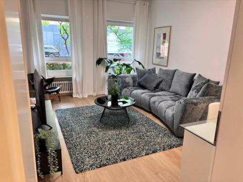 a living room with a couch and a table at RaumtoGo No1 Modernes Ruhiges 2-Schlafzimmer Apartment in Wiesbaden City & Park in Wiesbaden