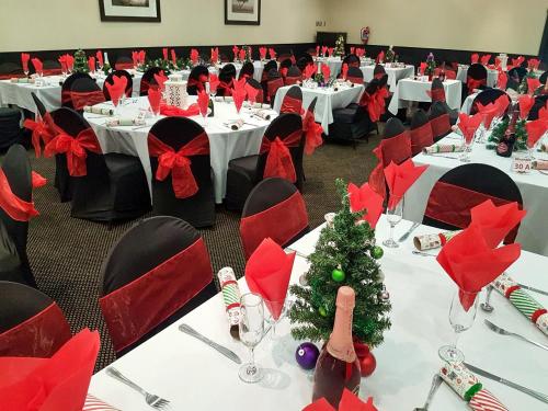 a banquet hall with white tables with red bows at Safari Hotel & Convention Centre in Rustenburg