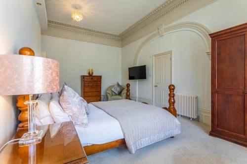 um quarto com uma cama e uma mesa com um candeeiro em Silversprings - City Centre Apartments with Parking em Exeter
