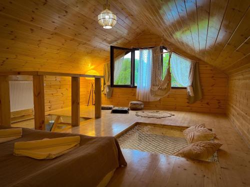 drewniany pokój z łóżkiem i oknem w obiekcie Teo's Cottages w mieście Dedoplis Tskaro