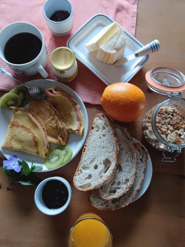 a table with a plate of bread and butter and coffee at Gite Les Volets Bleus du Segur in Le Ségur-Suech