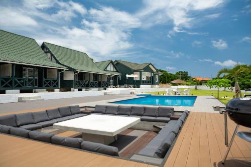 a patio with a couch and a table next to a pool at AK Resort ISHIGAKI in Ishigaki Island