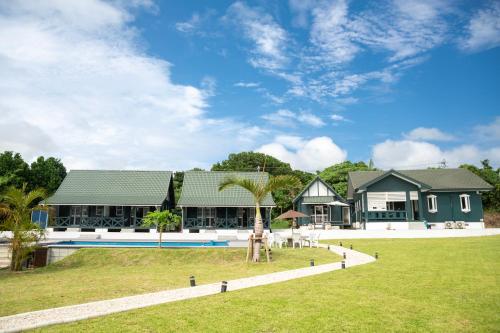 a house with a palm tree in front of it at AK Resort ISHIGAKI in Ishigaki Island