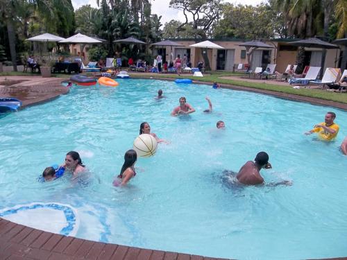 a group of people playing frisbee in a swimming pool at Safari Hotel & Convention Centre in Rustenburg