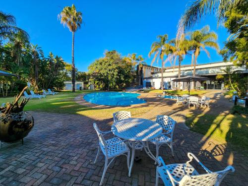 a patio with a table and chairs and a pool at Safari Hotel & Convention Centre in Rustenburg