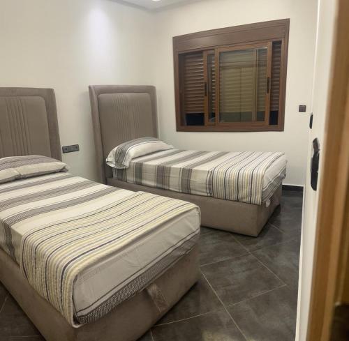 3 łóżka w pokoju z oknem w obiekcie House near beach w mieście Mʼdik