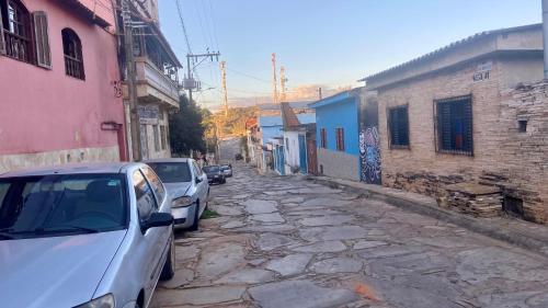 two cars parked on a stone road in an alley at Hostel Polansk in São Thomé das Letras