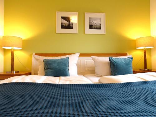1 dormitorio con 1 cama grande con almohadas azules en Gode Wind Quartiere 6, en Dahme