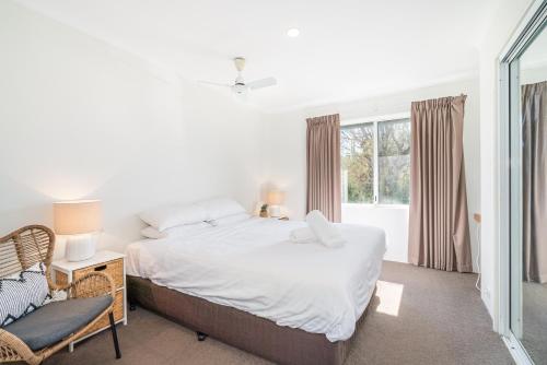 Abbys Beach Villa في Broadwater: غرفة نوم بيضاء مع سرير ونافذة