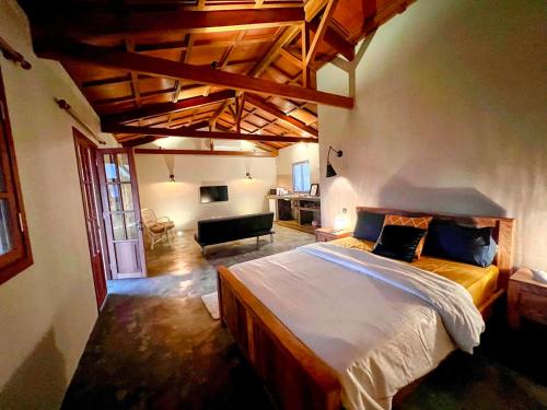 um quarto com uma cama grande e uma sala de estar em Lakaz Kannell - Room 1 - Dodo Lodge, secluded outside shower, infinity pool em Cap Malheureux