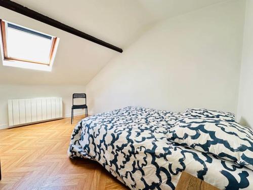 une chambre avec un lit, une fenêtre et une chaise dans l'établissement Morgan' Appartement, à Laon