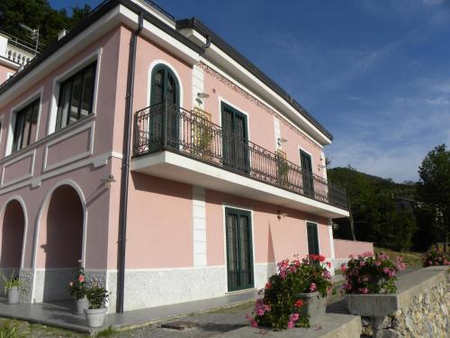 um edifício rosa com uma varanda e algumas flores em Guest House Cifrino em Giffoni Sei Casali