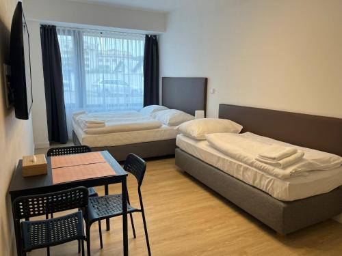 a room with two beds and a table and chairs at Post 120 Suites in Prague