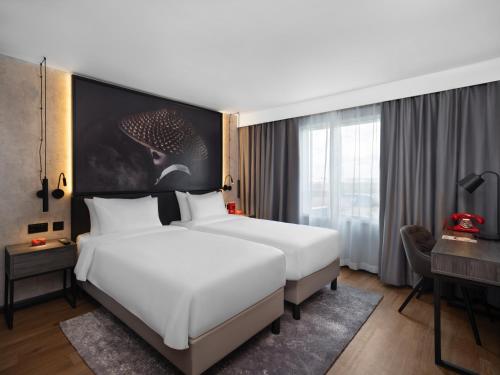 Habitación de hotel con 2 camas y escritorio en Radisson RED London Gatwick Airport en Crawley