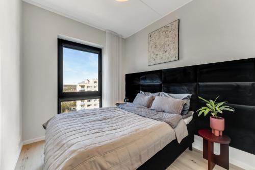 a bedroom with a large bed and a window at 15 korruse premium katusekorter in Tallinn