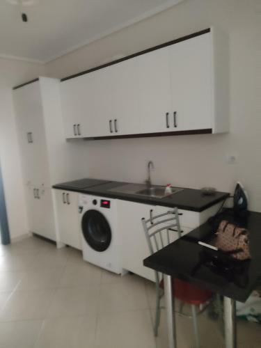 een wasruimte met een wastafel en een wasmachine bij Lukova Center Apartments in Lukovë