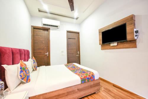 a bedroom with a bed and a tv on the wall at FabExpress 56 Amritsar in Amritsar
