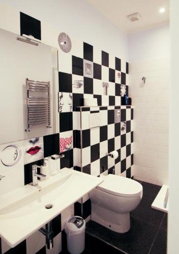 a bathroom with a black and white checkered wall at B&B Le Mura in Grosseto