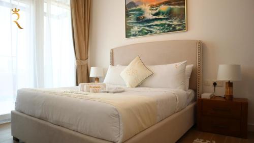 sypialnia z białym łóżkiem i dużym oknem w obiekcie City Chic: Elegant 1BR Apartment w Abu Zabi