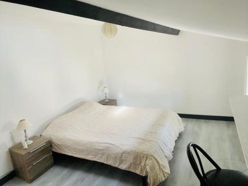 ein weißes Schlafzimmer mit einem Bett und einem Stuhl in der Unterkunft Maison très agréable et familiale Saintes Royan in La Jard