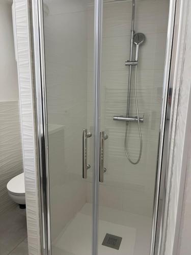 une douche avec une porte vitrée dans une salle de bain dans l'établissement Charmant 2P cœur de ville et plage, à Sainte-Maxime