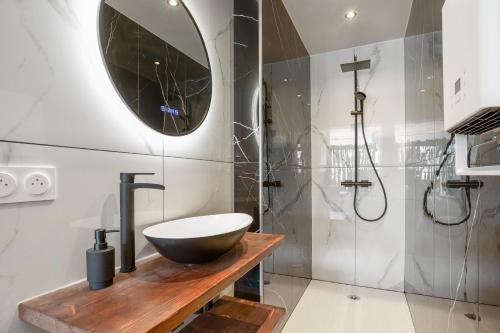 une salle de bain avec lavabo et douche dans l'établissement Bambou Heliopolis, au Cap d'Agde