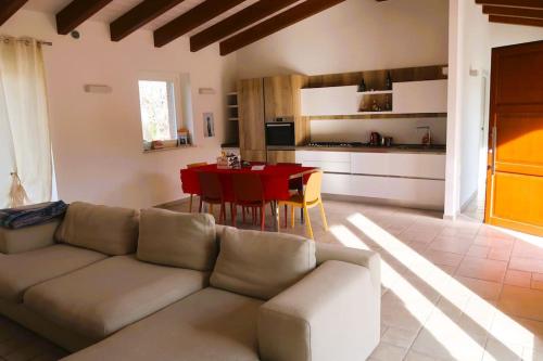 salon z kanapą i czerwonym stołem w obiekcie VILLA MILLEFIORI w mieście Tornareccio