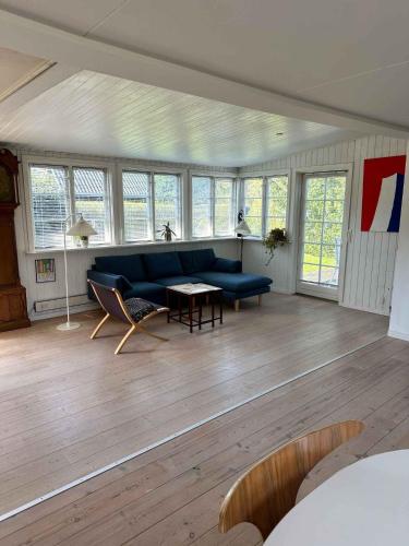 salon z niebieską kanapą i stołem w obiekcie Lovely Bright Summer House Close To Hornbæk, w mieście Hornbæk