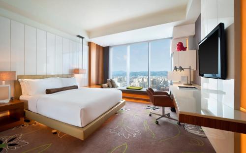 台北的住宿－台北W 酒店，酒店客房配有一张床、一张书桌和一台电视。
