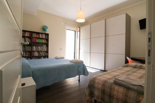 a bedroom with two beds and a book shelf at B&B Le Mura in Grosseto