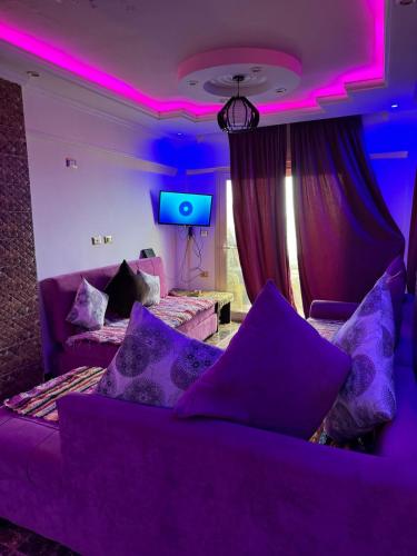 a purple room with a couch and a tv at Family Condo With Panoramic Sea View 1 in Alexandria