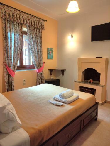a bedroom with a large bed with a fireplace at Triantafillies Traditional Hotel in Portariá