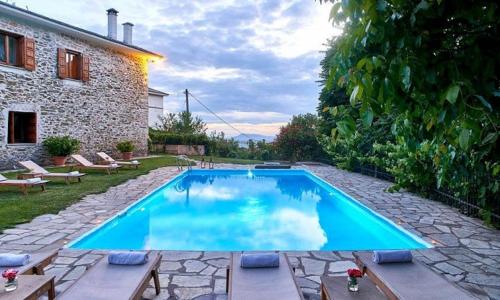 a swimming pool in the backyard of a house at Triantafillies Traditional Hotel in Portaria