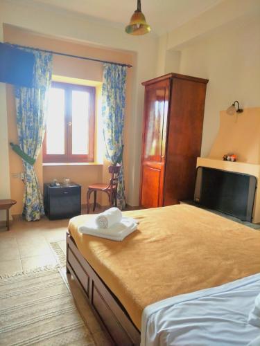 a bedroom with a large bed and a window at Triantafillies Traditional Hotel in Portaria