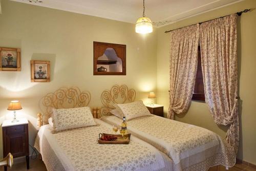 a bedroom with two beds and a window at Triantafillies Traditional Hotel in Portaria