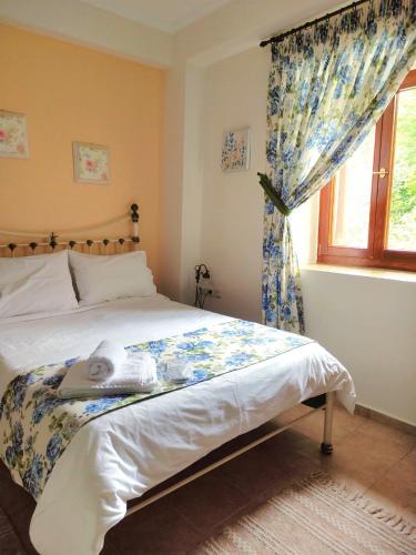 a bedroom with a large bed with a window at Triantafillies Traditional Hotel in Portariá