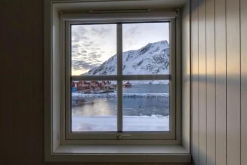 a window with a view of a snow covered mountain at Modern Fisherman Cabin in Ballstad