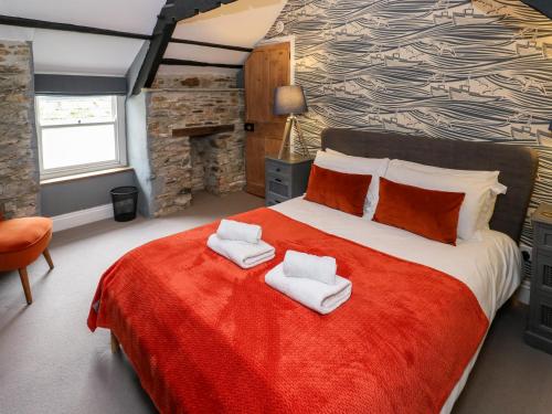 een slaapkamer met een groot bed met handdoeken erop bij Winterbrook Cottage in St Austell