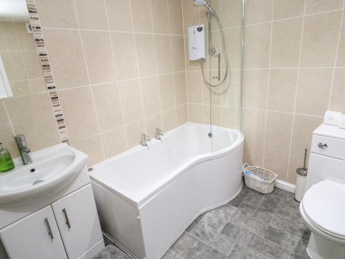 een badkamer met een bad, een wastafel en een toilet bij Winterbrook Cottage in St Austell