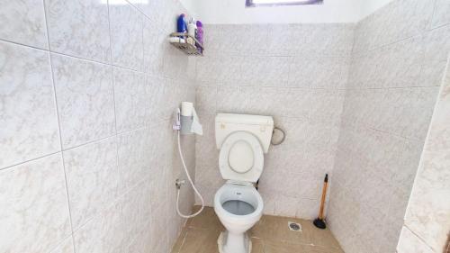 a bathroom with a toilet with a phone on the wall at Gee's Neat Apartment in Mombasa CBD / Parking 2 in Mombasa