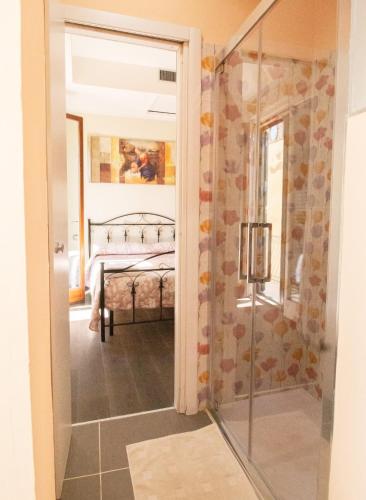 a bathroom with a glass door leading to a bedroom at B&B Le Mura in Grosseto