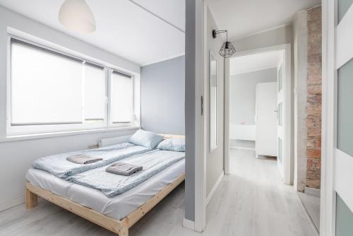 a bedroom with a bed and a window at Koliber by 3City Rentals in Gdynia