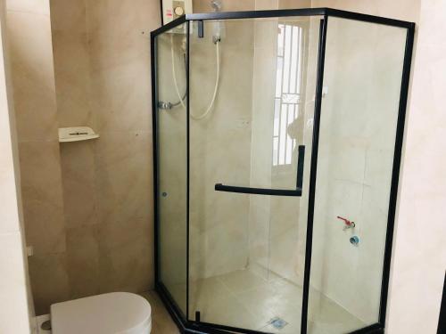 a shower stall with a toilet in a bathroom at Electricity Apartment Hotel in Vientiane