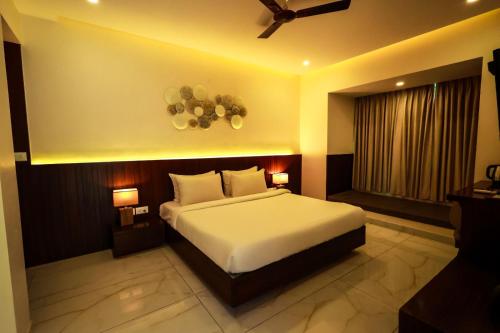 a bedroom with a large white bed and a window at Veerdency Luxury resort in Bangalore