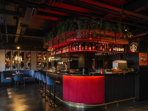 a bar with blue chairs and a red at Radisson RED London Gatwick Airport in Crawley